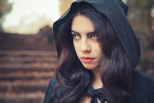 oman dressed in black with a hood with scary eyes