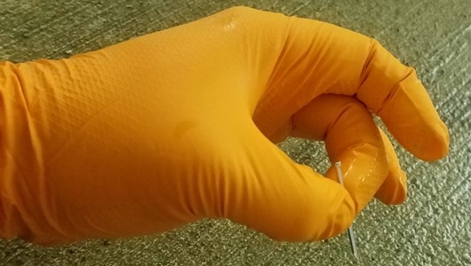 Grippaz Glove holding a small nail